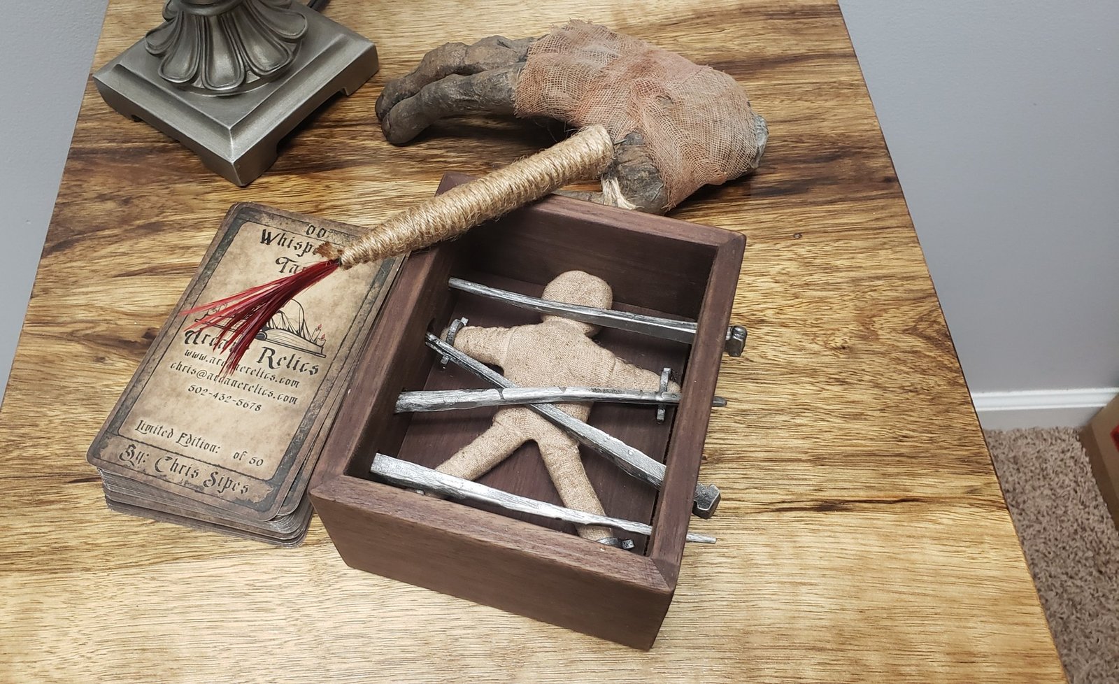 Caged Voodoo box on display with aged Arcane Relics cards